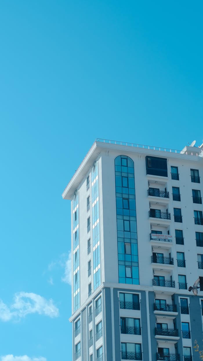 our-services-03 Contemporary apartment building facade with blue sky, showcasing modern architecture.