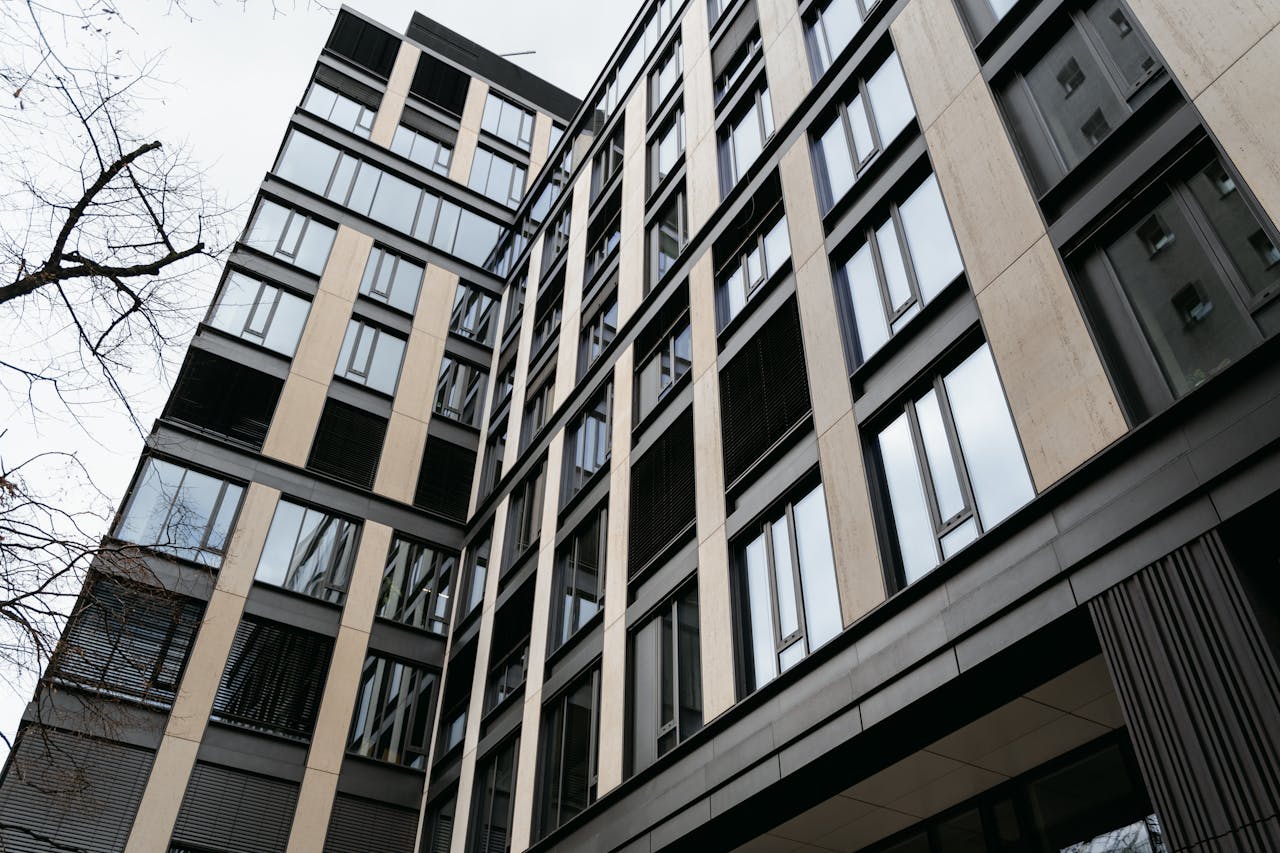 about-us-02 Low-angle view of a modern building exterior showcasing glass and steel architectural elements.